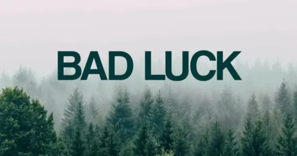 Bad Luck text over foggy pine forest background